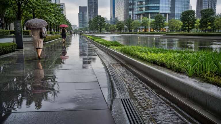 Rua urbana com canal de drenagem e corredores verdes contra enchentes